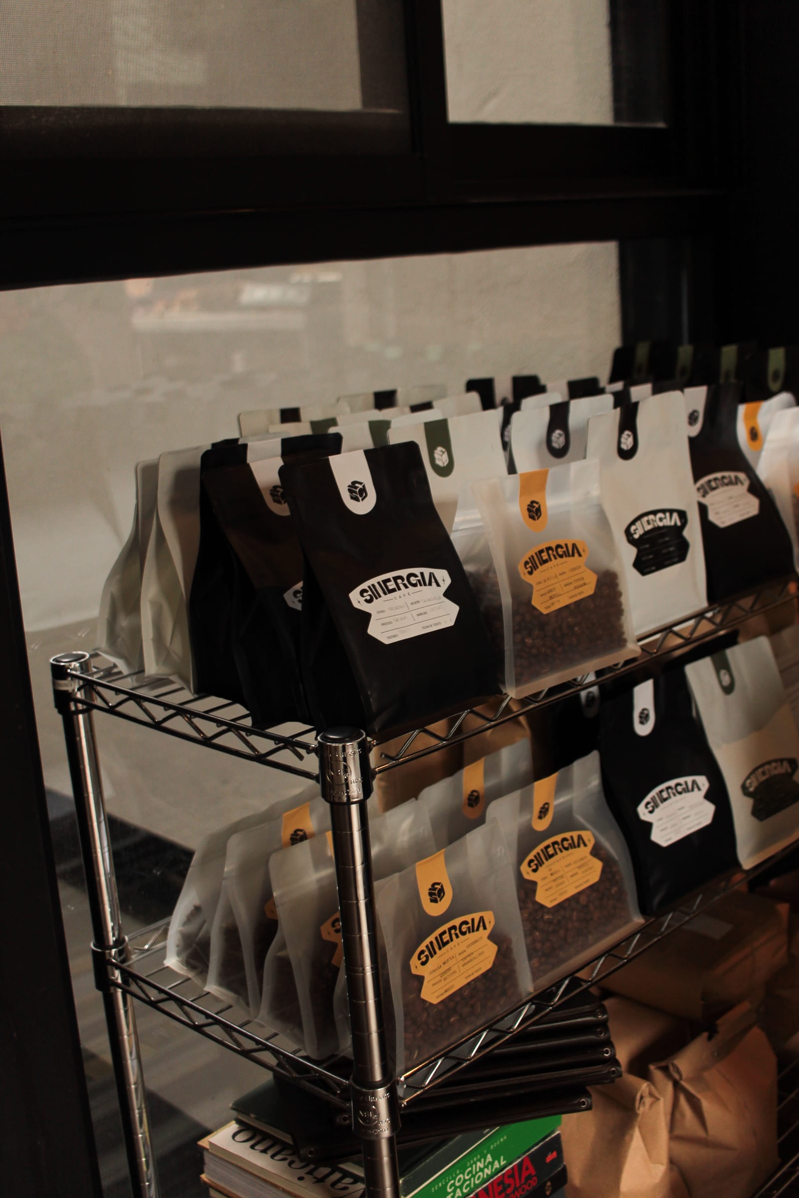 Bolsas de café de especialidad Sinergia junto al ventanal de la cafetería