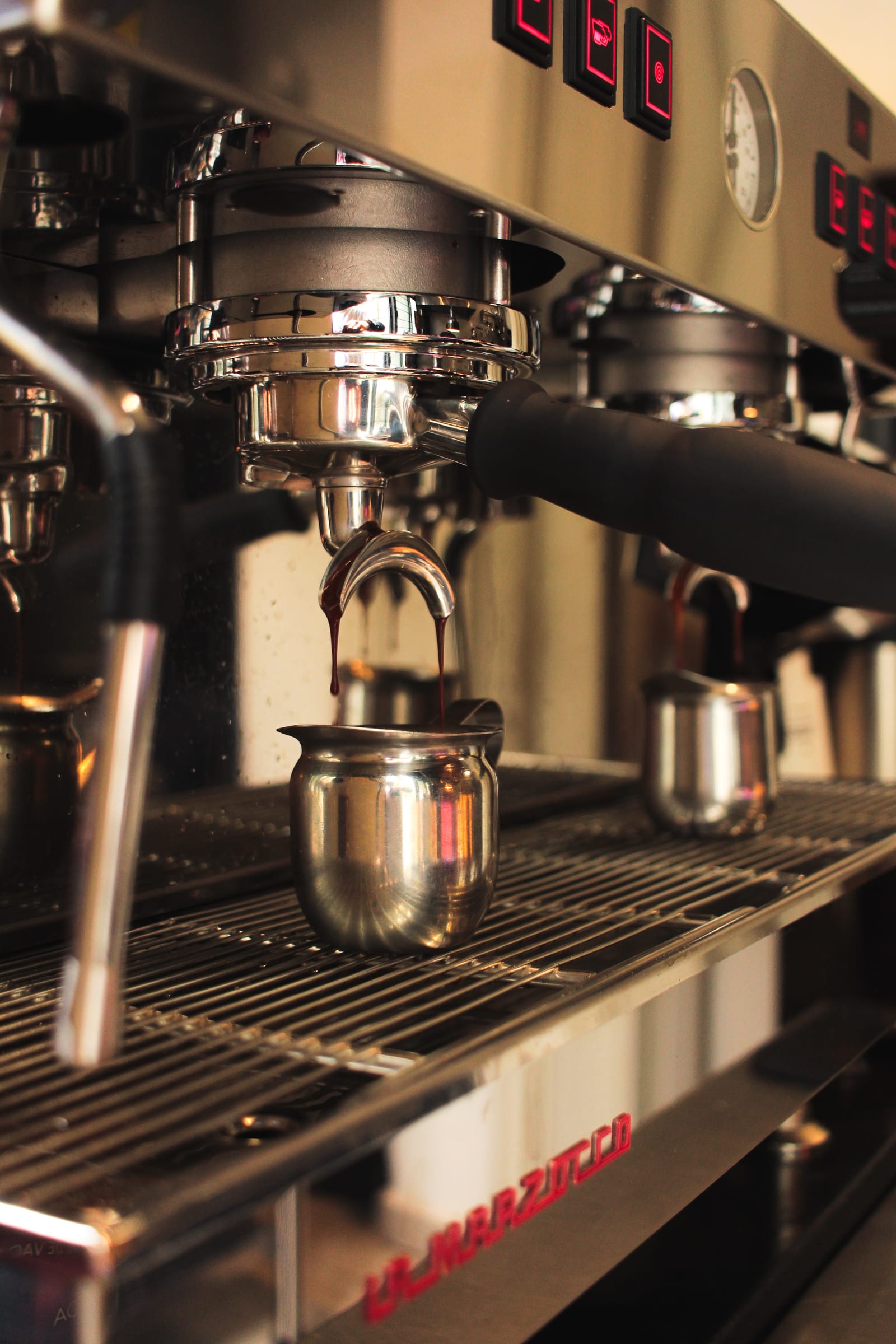 Máquina de espresso La Marzocco con una jarra bajo el portafiltro
